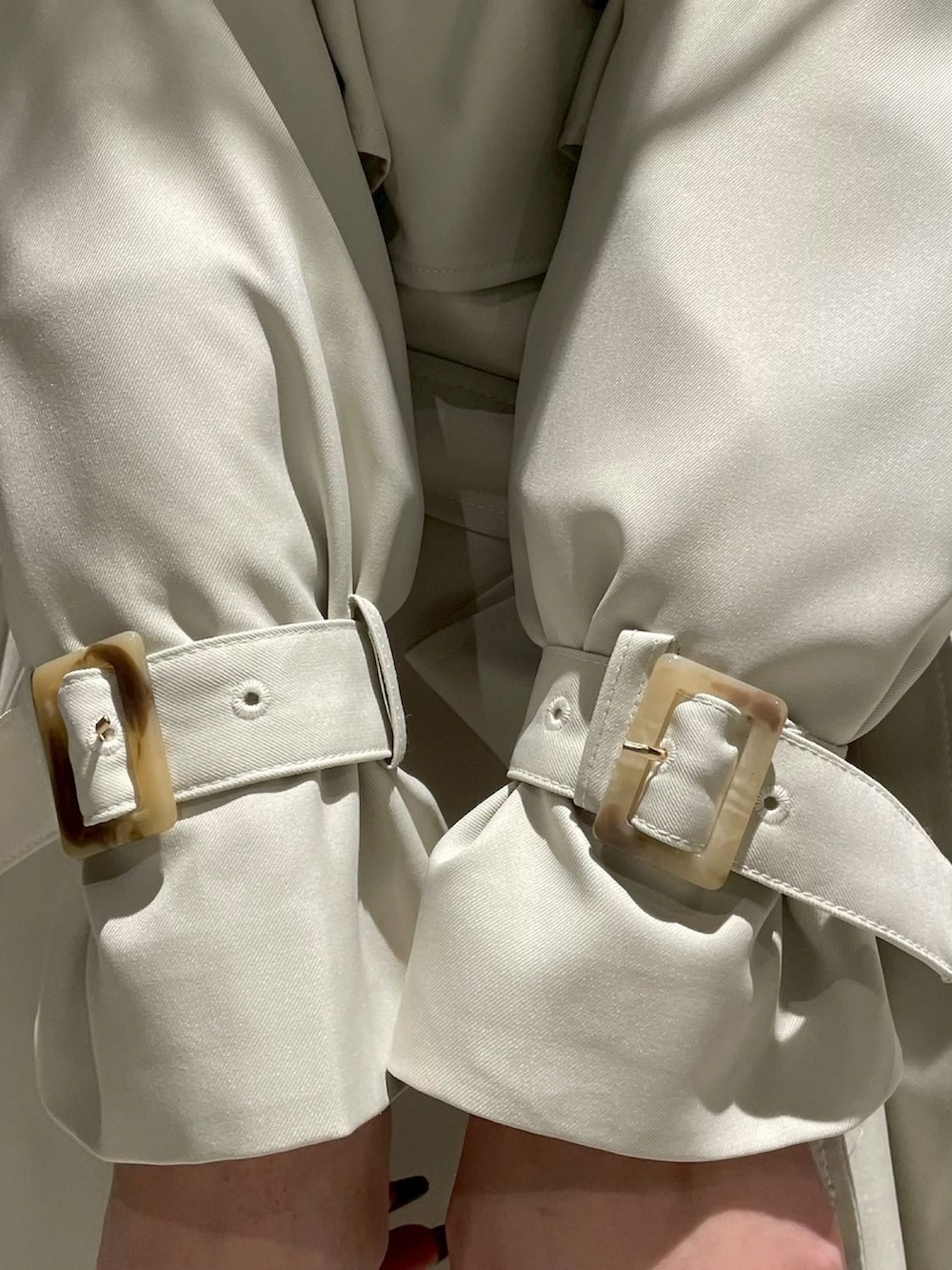 ブラウン系のスカート、イエロー系のニット/セーター、グリーン系のトレンチコートを着用したレディースの冬コーディネートの5枚目の写真