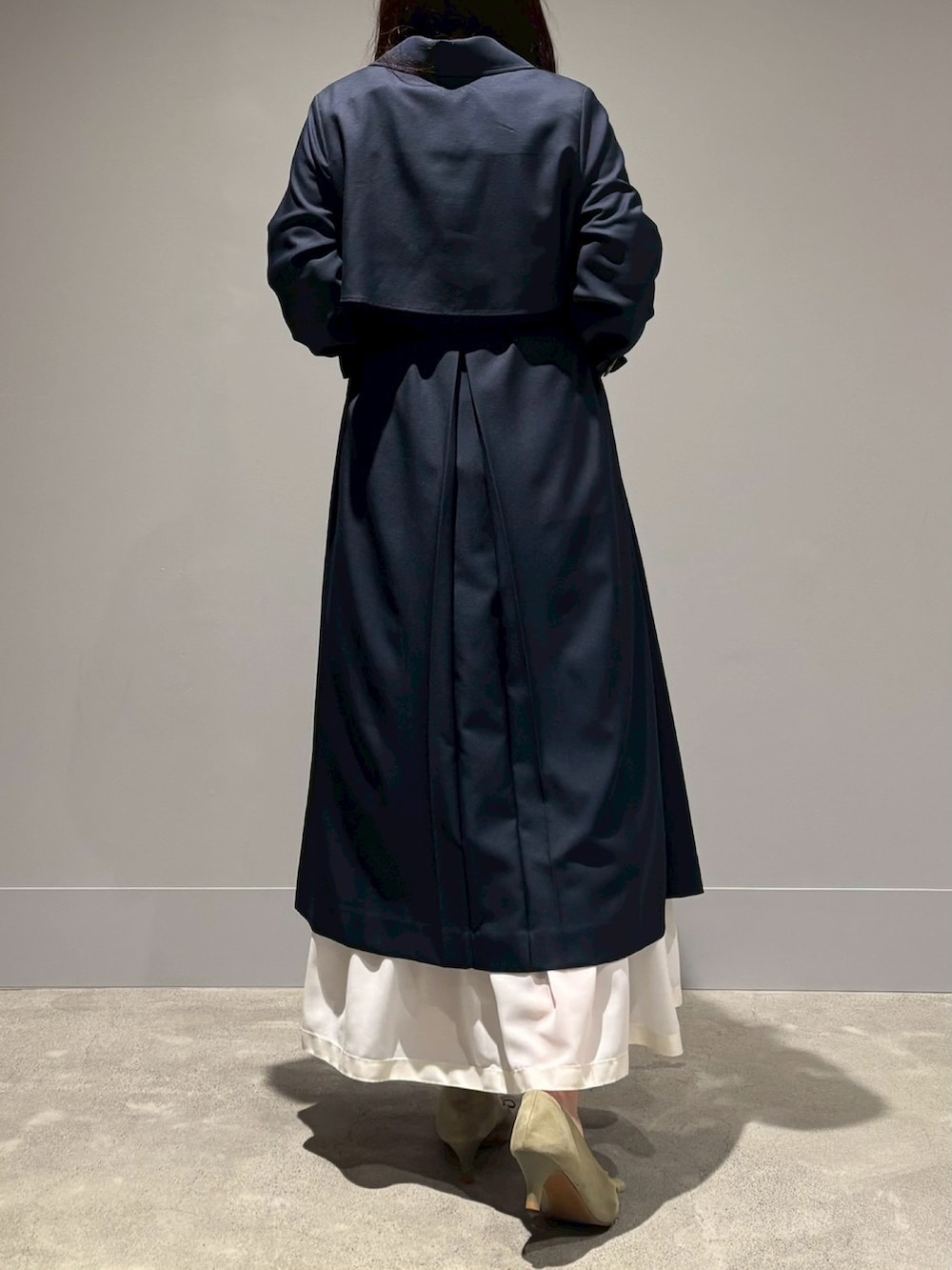 ブルー系のトレンチコート、ホワイト系のスカートを着用したレディースの春コーディネートの3枚目の写真