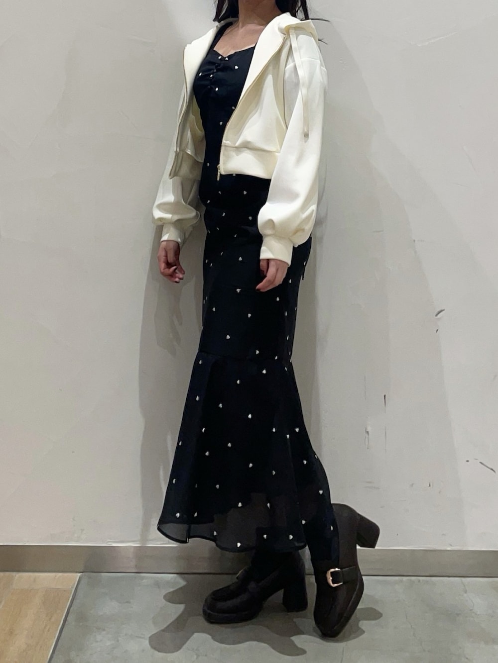 イエロー系のパーカー、ブラック系のワンピースを着用したレディースの冬コーディネートの2枚目の写真