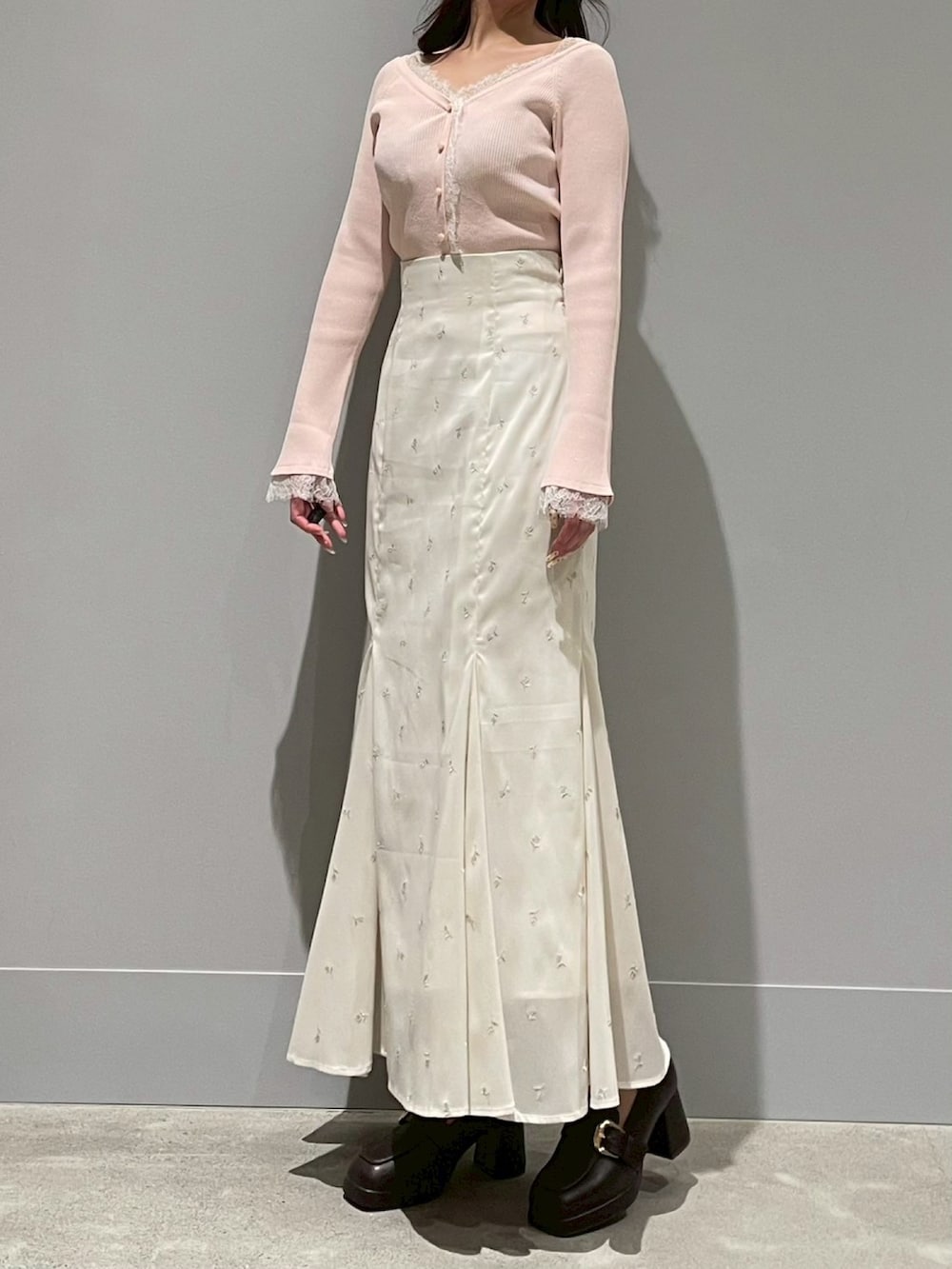 ホワイト系のスカート、ピンク系のニット/セーターを着用したレディースの春コーディネートの2枚目の写真