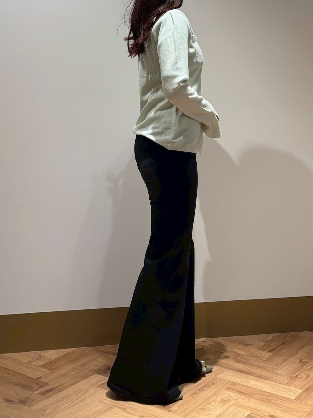 グリーン系のニット/セーター、ブラック系のその他パンツを着用したレディースの春コーディネートの2枚目の写真