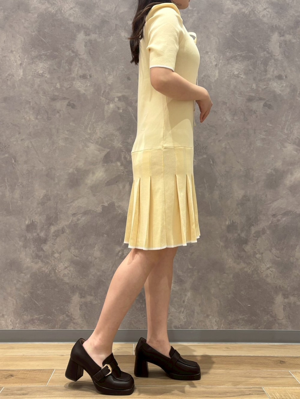 イエロー系のワンピースを着用したレディースの春コーディネートの2枚目の写真