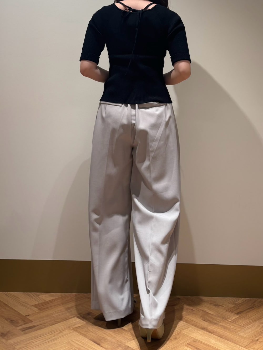 イエロー系のニット/セーター、グレー系のその他パンツを着用したレディースの春コーディネートの3枚目の写真