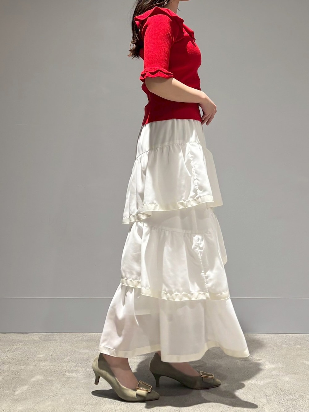 ホワイト系のニット/セーター、ホワイト系のスカートを着用したレディースの春コーディネートの2枚目の写真