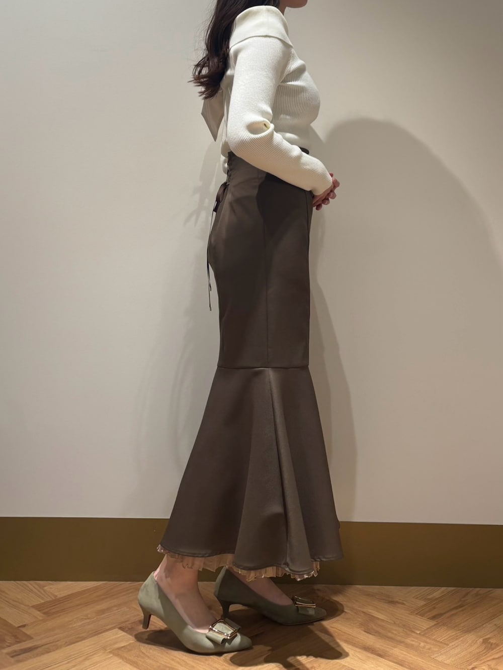 ホワイト系のニット/セーター、ブラウン系のスカートを着用したレディースの春コーディネートの3枚目の写真