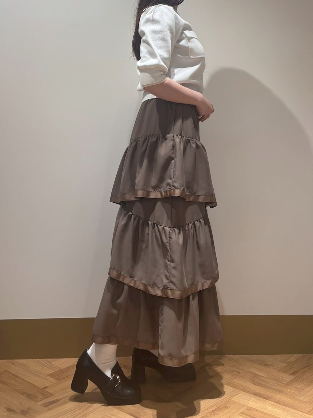 ブラウン系のスカート、ホワイト系のカーディガン/ボレロを着用したレディースの春コーディネートの2枚目の写真