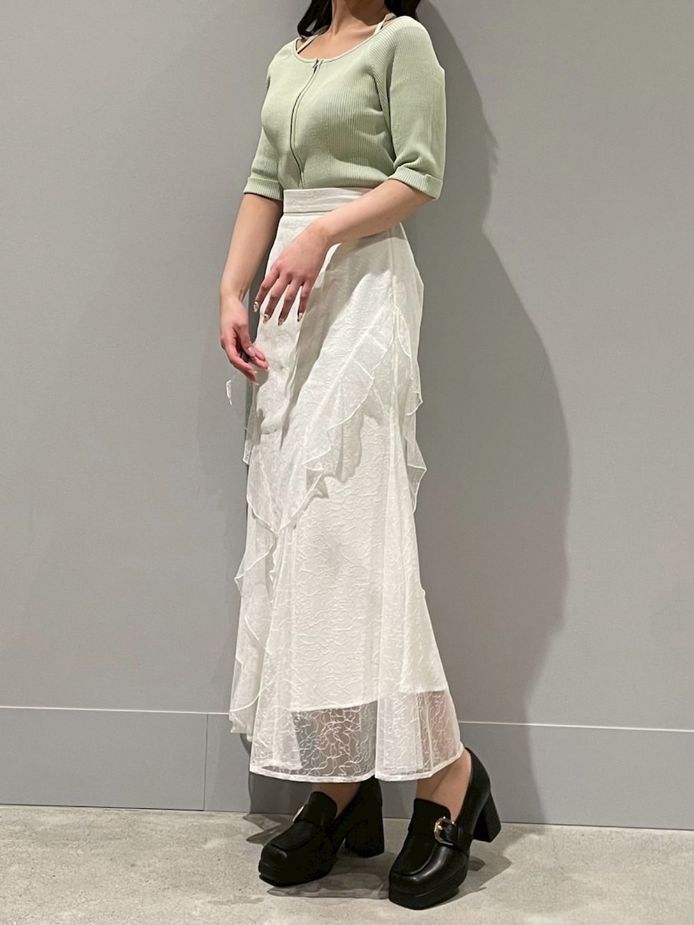 ホワイト系のスカート、イエロー系のニット/セーターを着用したレディースの春コーディネートの2枚目の写真