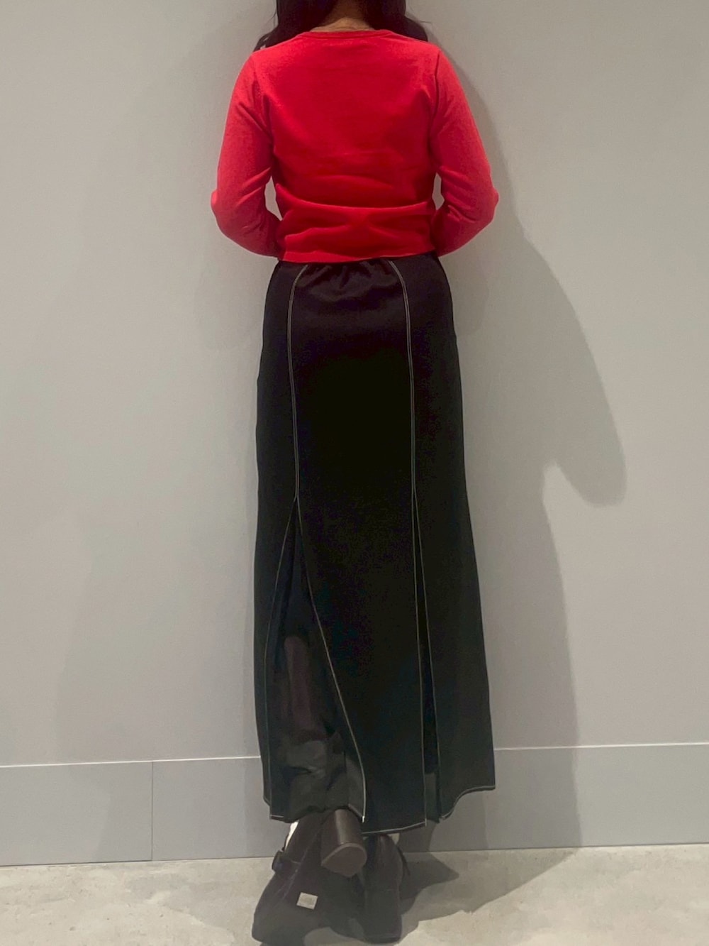 レッド系のカーディガン/ボレロ、ブラック系のスカートを着用したレディースの冬コーディネートの3枚目の写真