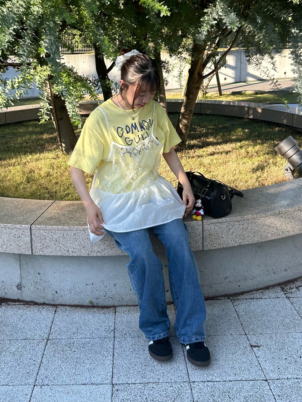 ホワイト系のTシャツ/カットソー、ブラック系のスニーカー、イエロー系のTシャツ/カットソーを着用したレディースの秋コーディネートの2枚目の写真