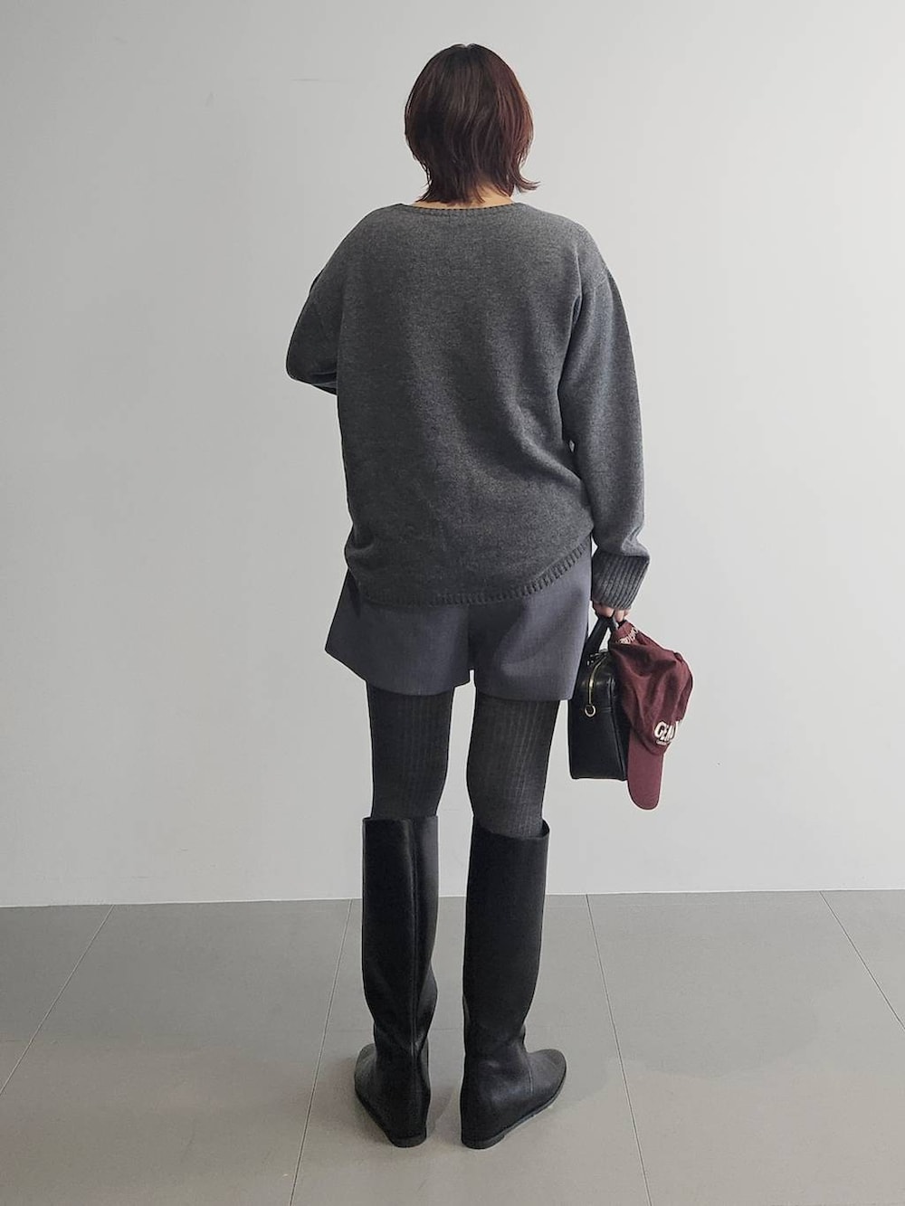 グレー系のニット/セーター、グレー系のその他パンツ、ブラック系のボストンバッグを着用したレディースの秋コーディネートの6枚目の写真