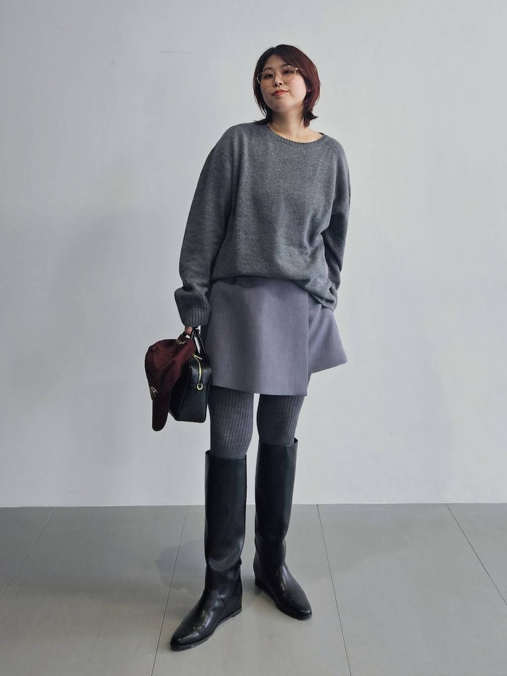 グレー系のニット/セーター、グレー系のその他パンツ、ブラック系のボストンバッグを着用したレディースの秋コーディネートの2枚目の写真