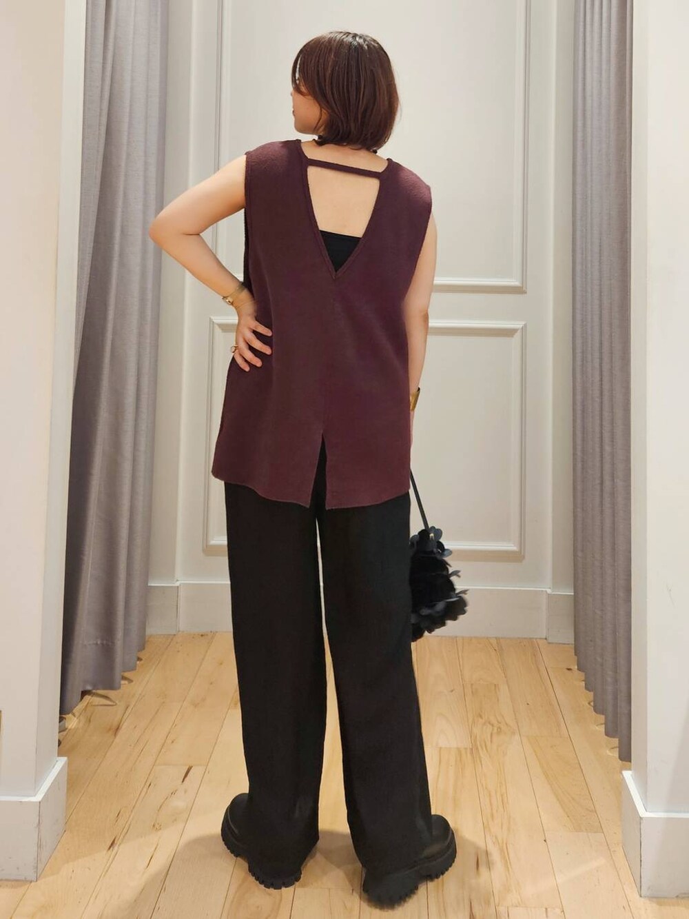 ブラック系のその他パンツ、ブラック系のキャミソール、レッド系のベストを着用したレディースの夏コーディネートの5枚目の写真