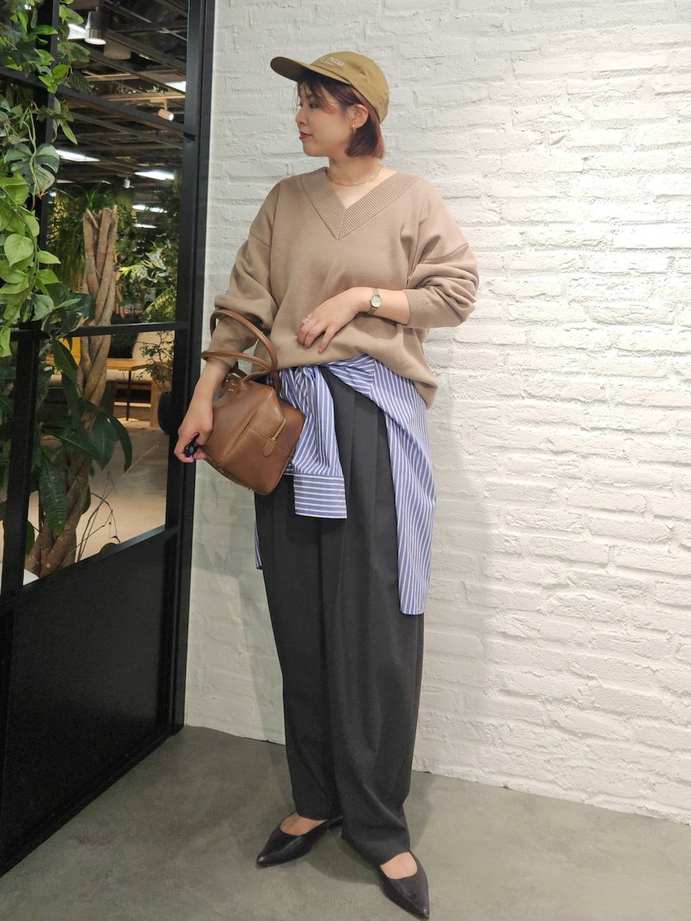 グレー系のその他パンツ、ブラウン系のハンドバッグ、ベージュ系のスウェットを着用したレディースの秋コーディネートの2枚目の写真