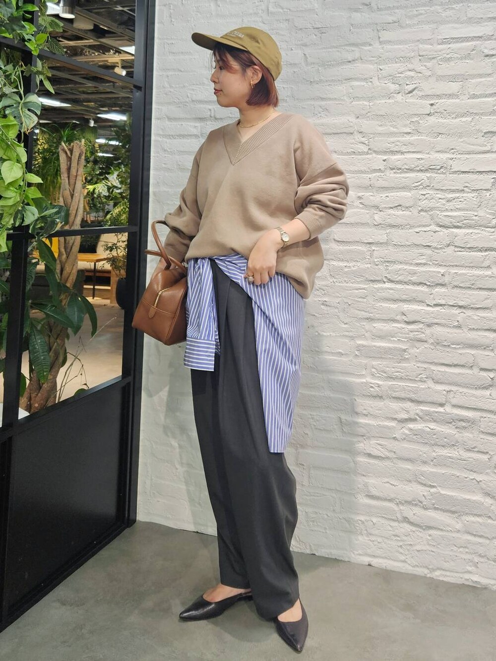 グレー系のその他パンツ、ブラウン系のハンドバッグ、ベージュ系のスウェットを着用したレディースの秋コーディネートの4枚目の写真