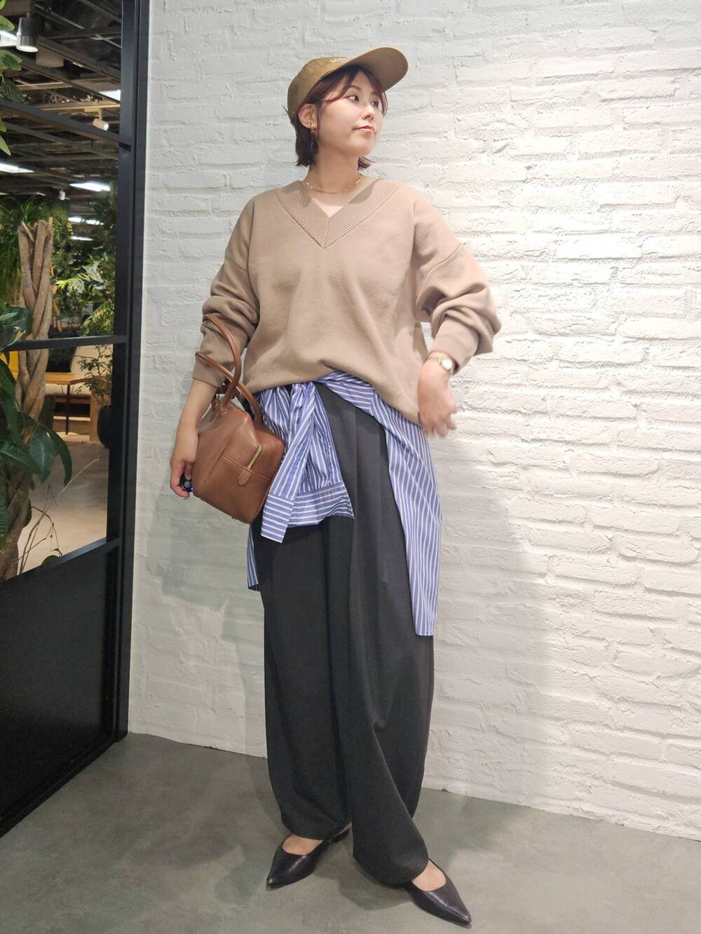 グレー系のその他パンツ、ブラウン系のハンドバッグ、ベージュ系のスウェットを着用したレディースの秋コーディネートの3枚目の写真