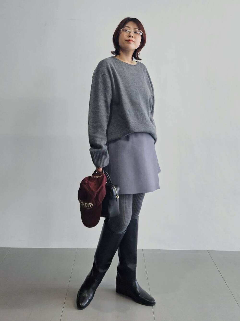グレー系のニット/セーター、グレー系のその他パンツ、ブラック系のボストンバッグを着用したレディースの秋コーディネートの3枚目の写真