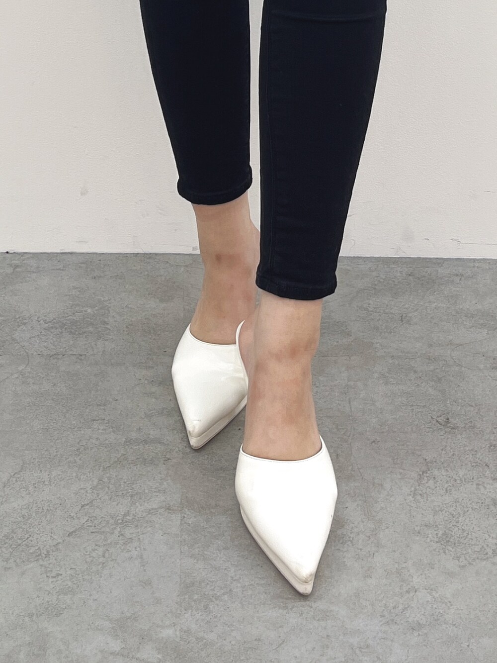 グレー系のTシャツ/カットソー、ブラック系のデニムパンツ、ホワイト系のパンプスを着用したレディースの春コーディネートの7枚目の写真