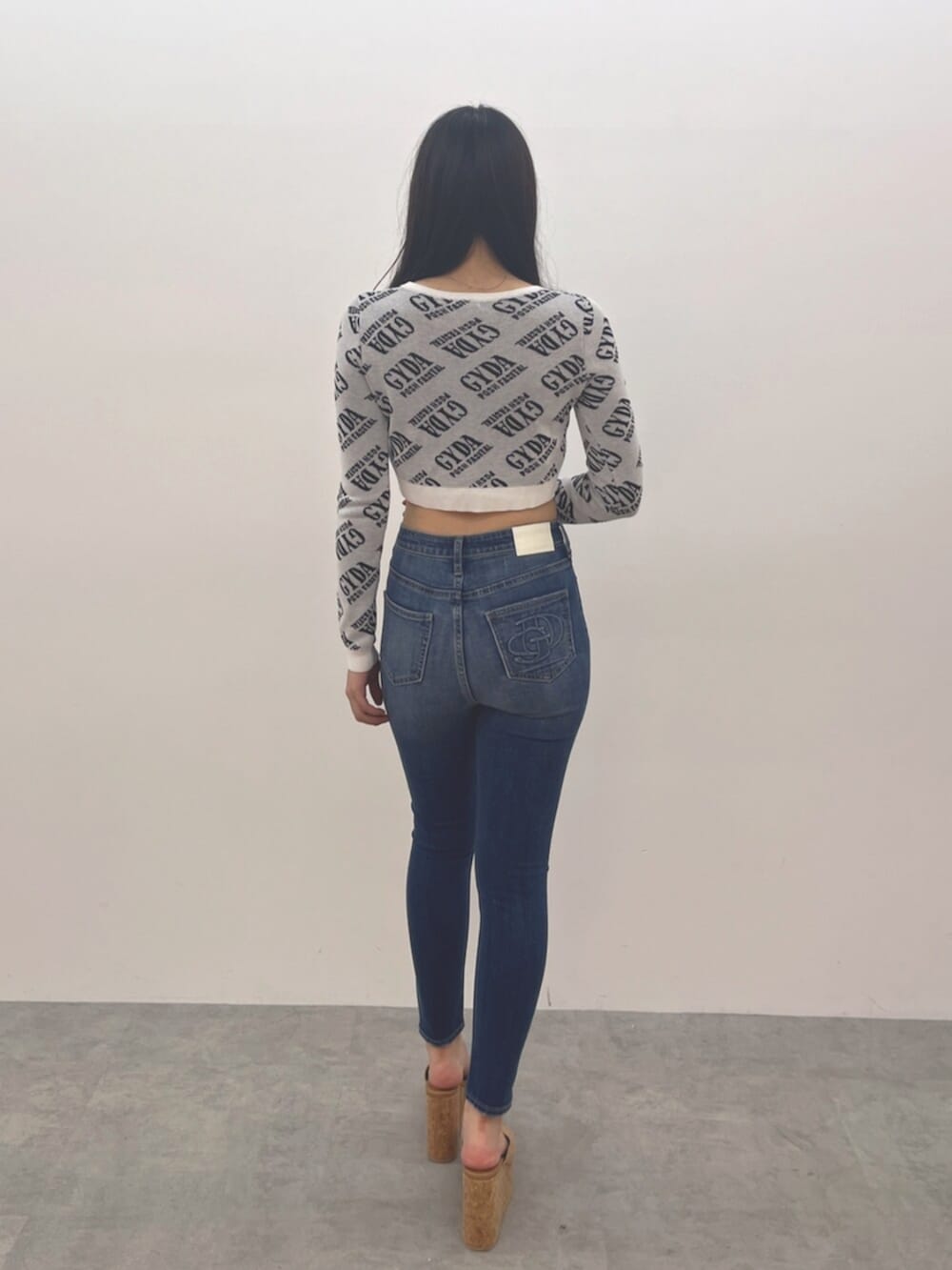 ブルー系のデニムパンツ、ホワイト系のカーディガン/ボレロ、ベージュ系のサンダルを着用したレディースの夏コーディネートの4枚目の写真