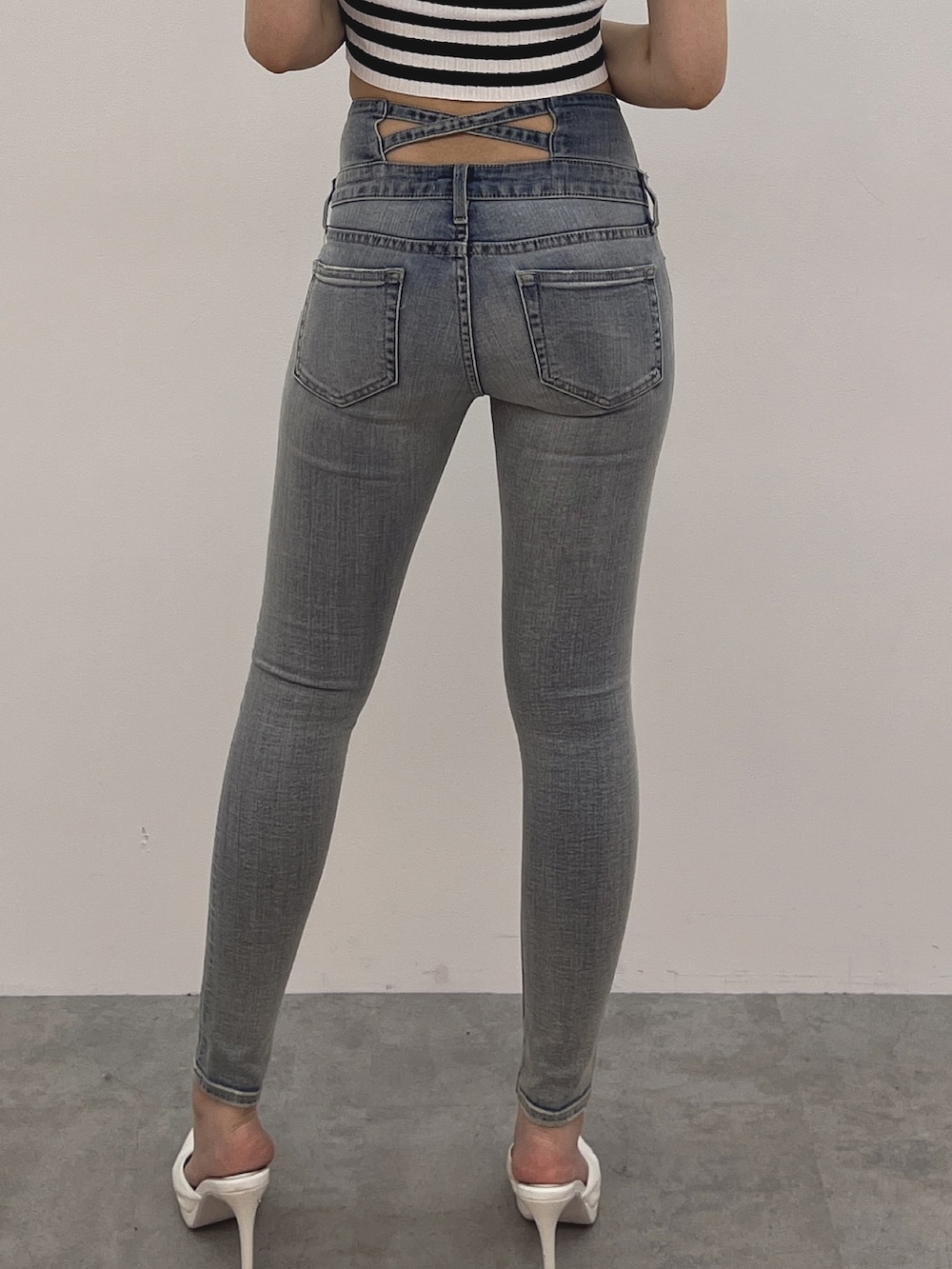 ブルー系のデニムパンツ、ホワイト系のパンプス、その他のニット/セーターを着用したレディースの春コーディネートの7枚目の写真