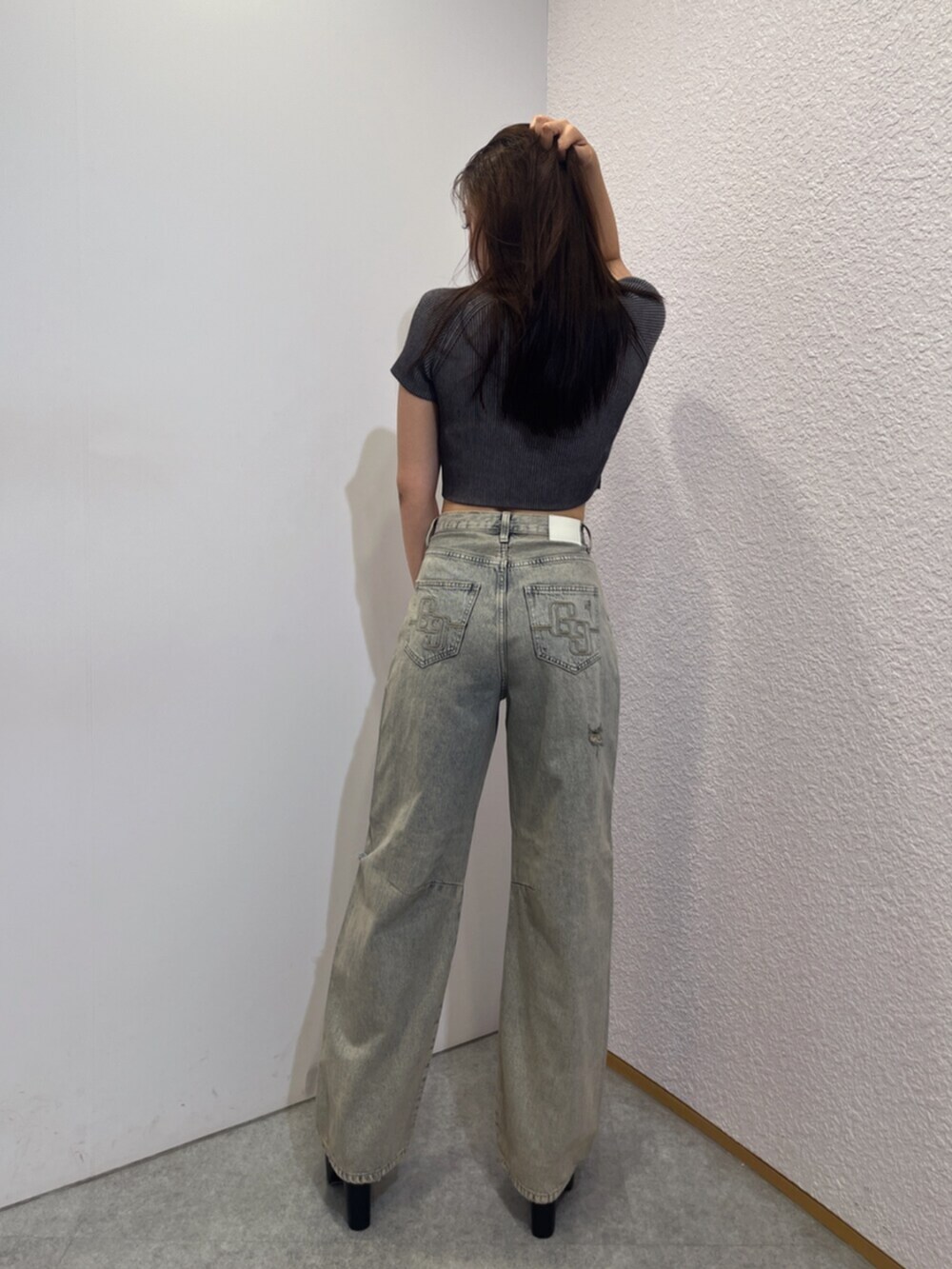 ブラック系のブーツ、ブルー系のデニムパンツ、ブラック系のニット/セーターを着用したレディースの夏コーディネートの3枚目の写真