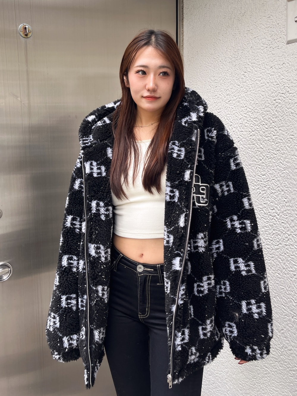 ブラック系のブルゾン、ホワイト系のTシャツ/カットソー、ブラック系のデニムパンツを着用したレディースの冬コーディネートの4枚目の写真