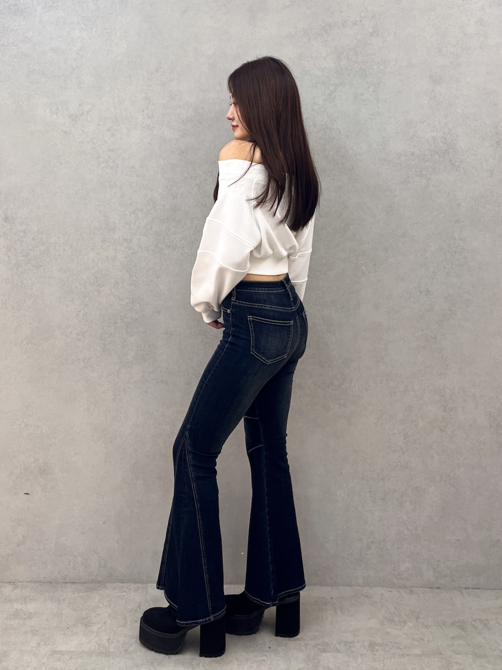 ブルー系のデニムパンツ、ブラック系のブーツ、ホワイト系のTシャツ/カットソーを着用したレディースの秋コーディネートの2枚目の写真