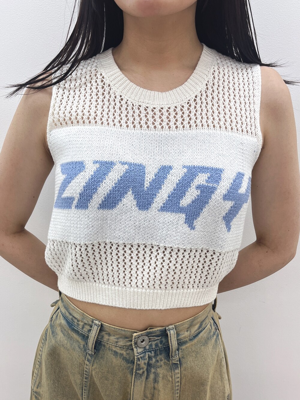 ホワイト系のタンクトップ、ブルー系のデニムパンツ、ホワイト系のパンプスを着用したレディースの夏コーディネートの6枚目の写真