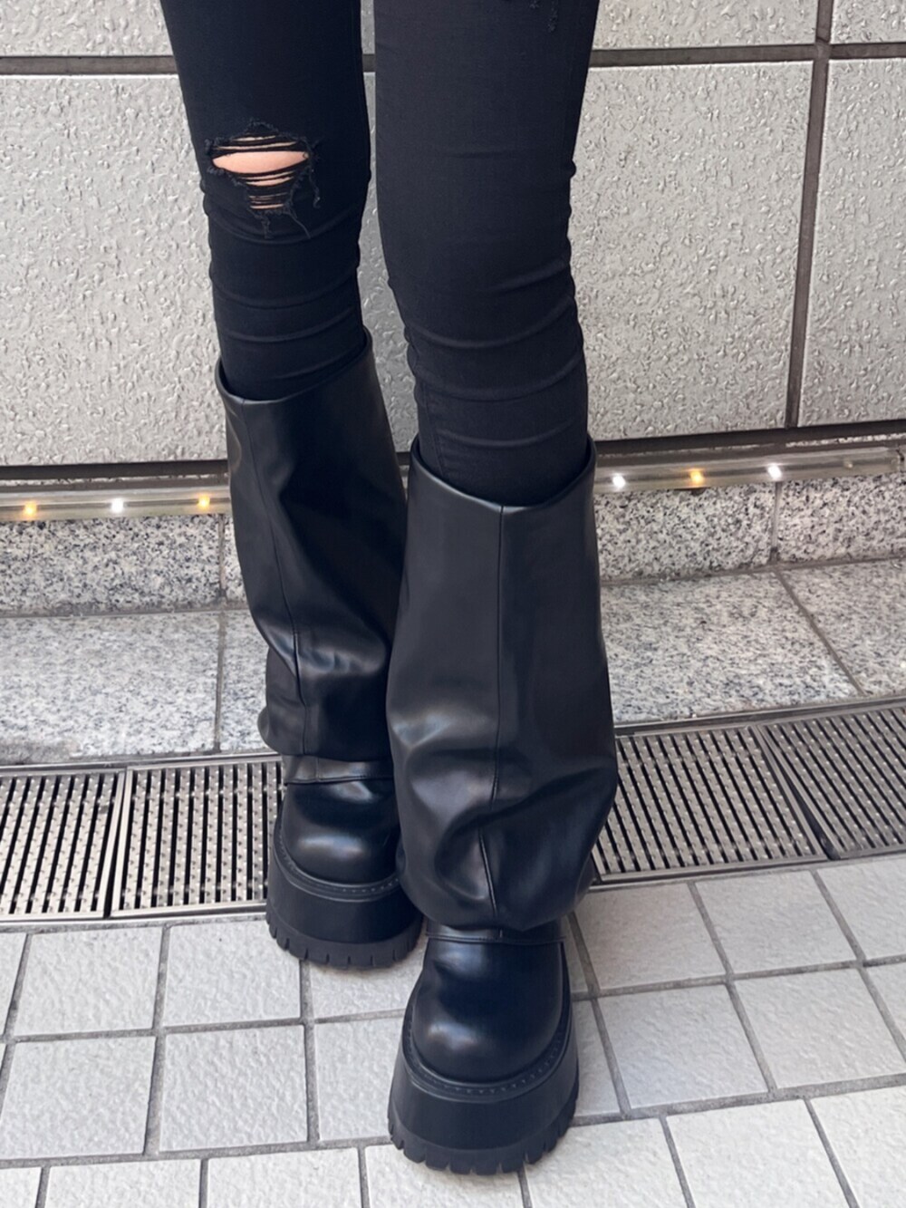 ブラック系のデニムパンツ、ブラック系のブーツ、レッド系のニット/セーターを着用したレディースの秋コーディネートの4枚目の写真