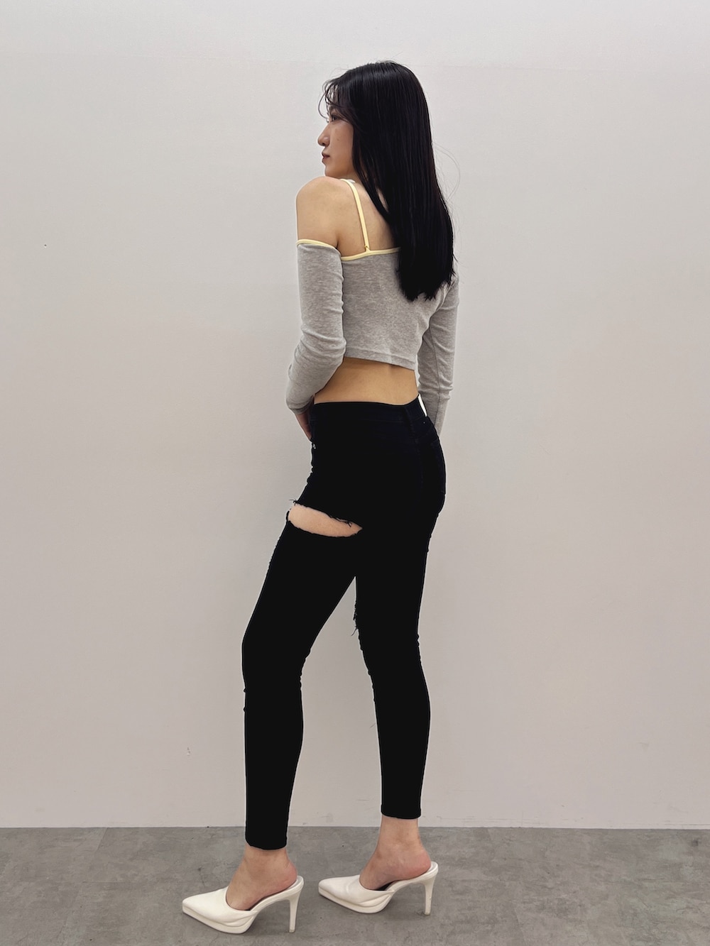 グレー系のTシャツ/カットソー、ブラック系のデニムパンツ、ホワイト系のパンプスを着用したレディースの春コーディネートの2枚目の写真