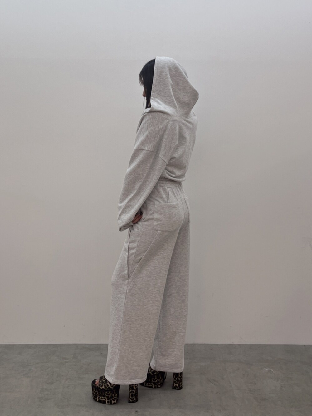 ホワイト系のキャミソール、グレー系のパーカー、グレー系のスウェットパンツを着用したレディースの春コーディネートの2枚目の写真