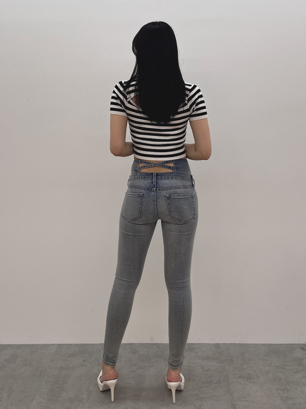 ブルー系のデニムパンツ、ホワイト系のパンプス、その他のニット/セーターを着用したレディースの春コーディネートの3枚目の写真