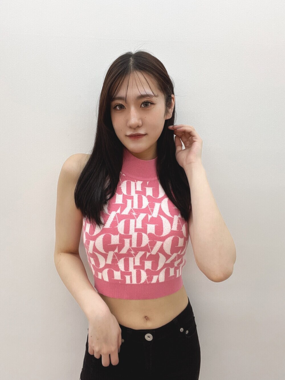 ブラック系のデニムパンツ、ピンク系のニット/セーター、ホワイト系のサンダルを着用したレディースの春コーディネートの6枚目の写真