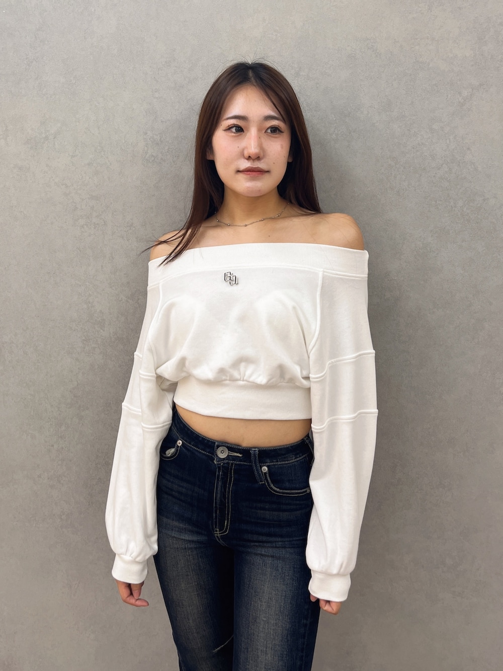 ブルー系のデニムパンツ、ブラック系のブーツ、ホワイト系のTシャツ/カットソーを着用したレディースの秋コーディネートの4枚目の写真