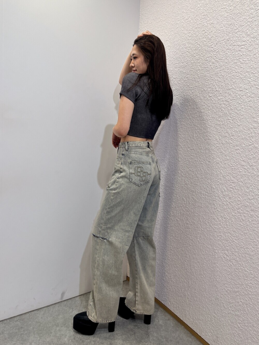 ブラック系のブーツ、ブルー系のデニムパンツ、ブラック系のニット/セーターを着用したレディースの夏コーディネートの2枚目の写真