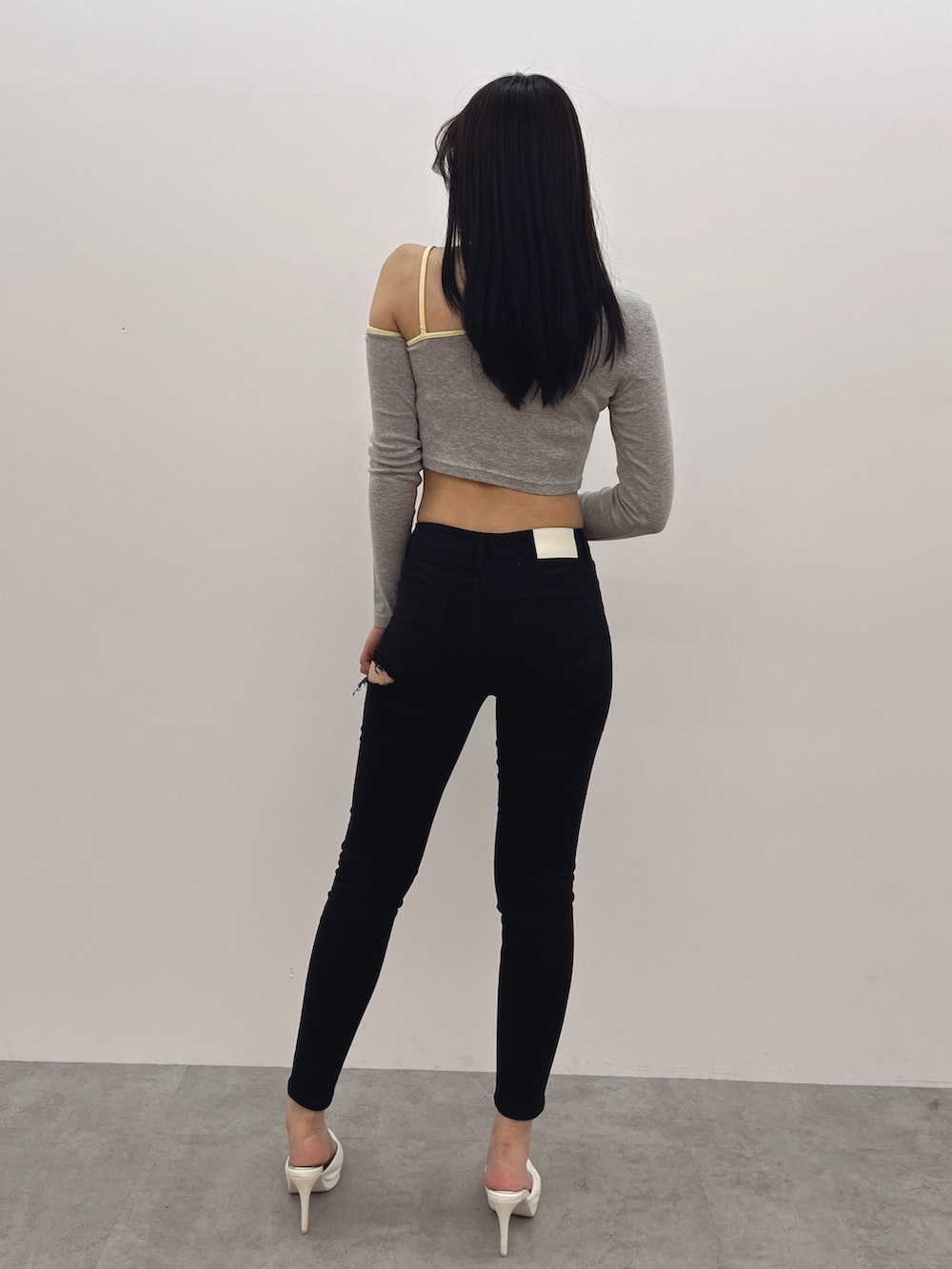 グレー系のTシャツ/カットソー、ブラック系のデニムパンツ、ホワイト系のパンプスを着用したレディースの春コーディネートの3枚目の写真