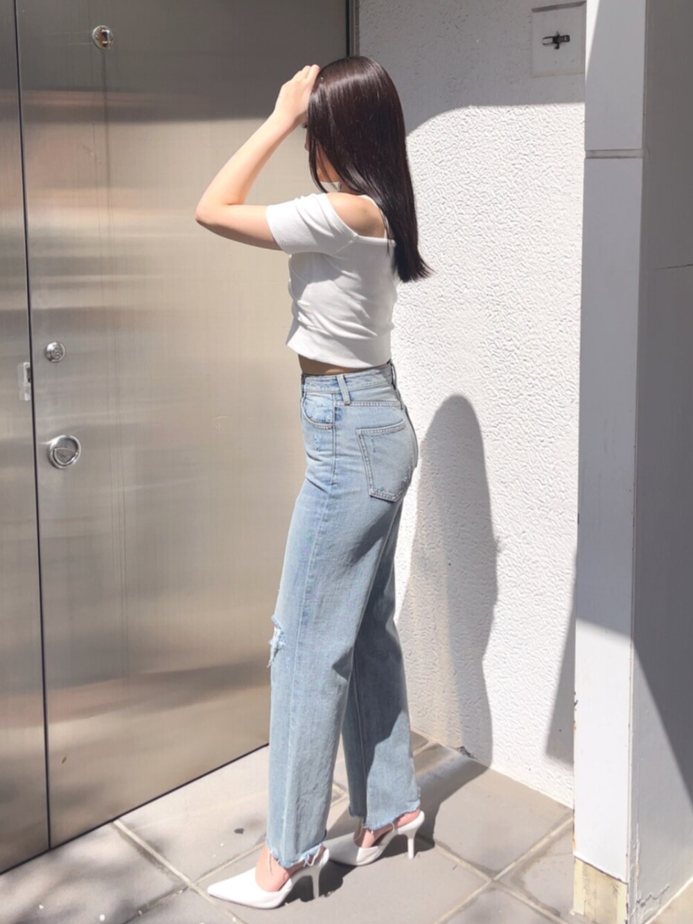 ホワイト系のパンプス、ブルー系のデニムパンツ、ホワイト系のTシャツ/カットソーを着用したレディースの春コーディネートの2枚目の写真