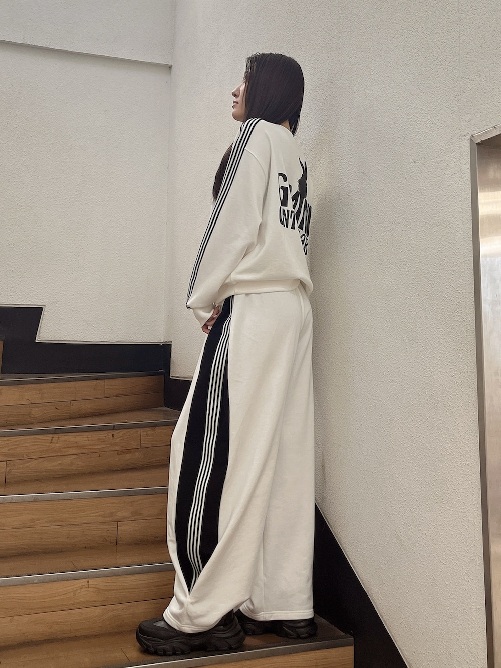 ホワイト系のスウェット、ホワイト系のスウェットパンツ、ブラック系のスニーカーを着用したレディースの冬コーディネートの2枚目の写真