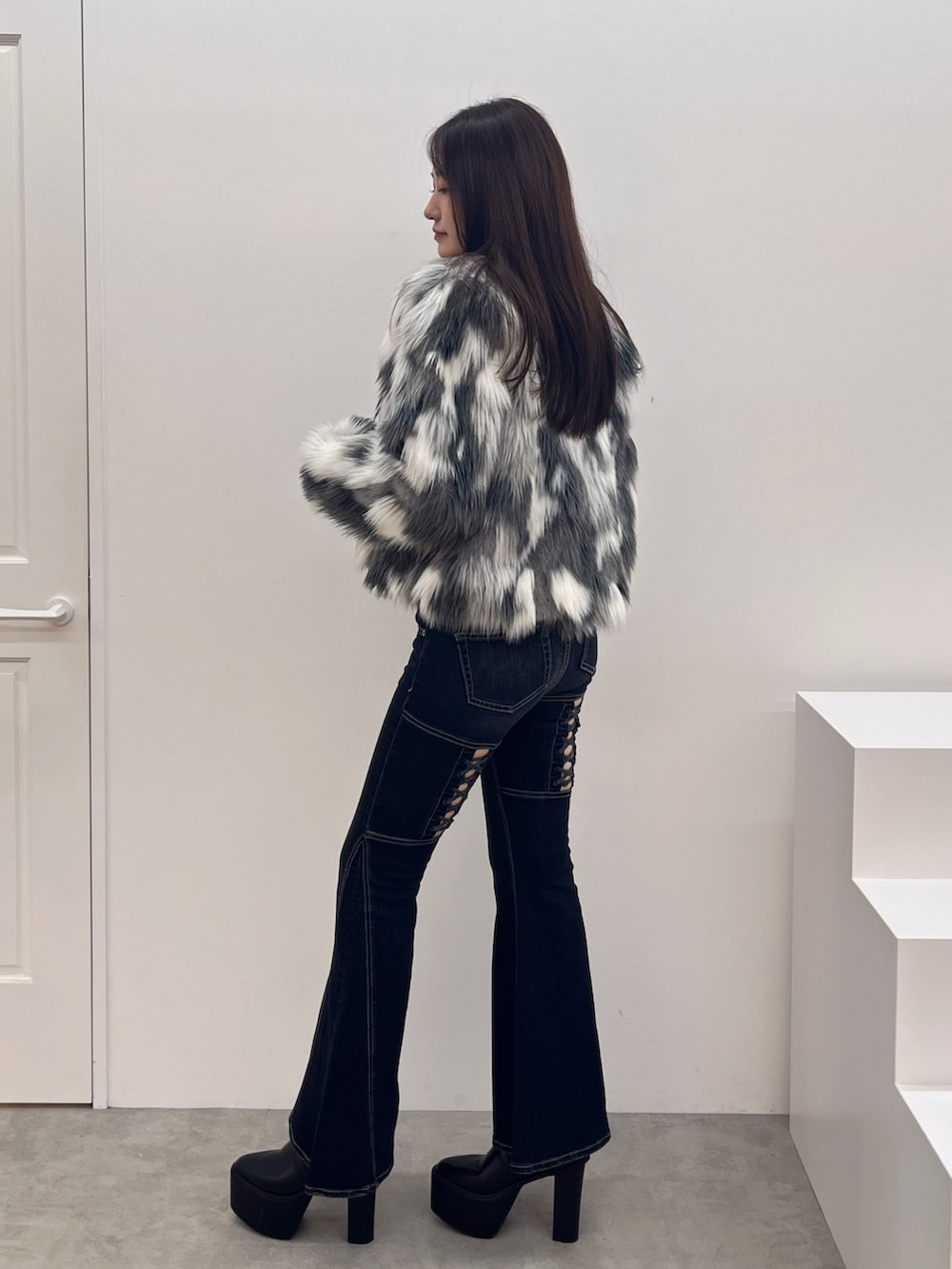 ブラック系のブーツ、シルバー系のニット/セーター、ブルー系のデニムパンツを着用したレディースの秋コーディネートの2枚目の写真