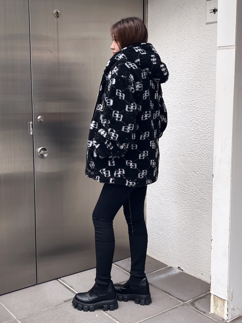 ブラック系のブルゾン、ホワイト系のTシャツ/カットソー、ブラック系のデニムパンツを着用したレディースの冬コーディネートの2枚目の写真