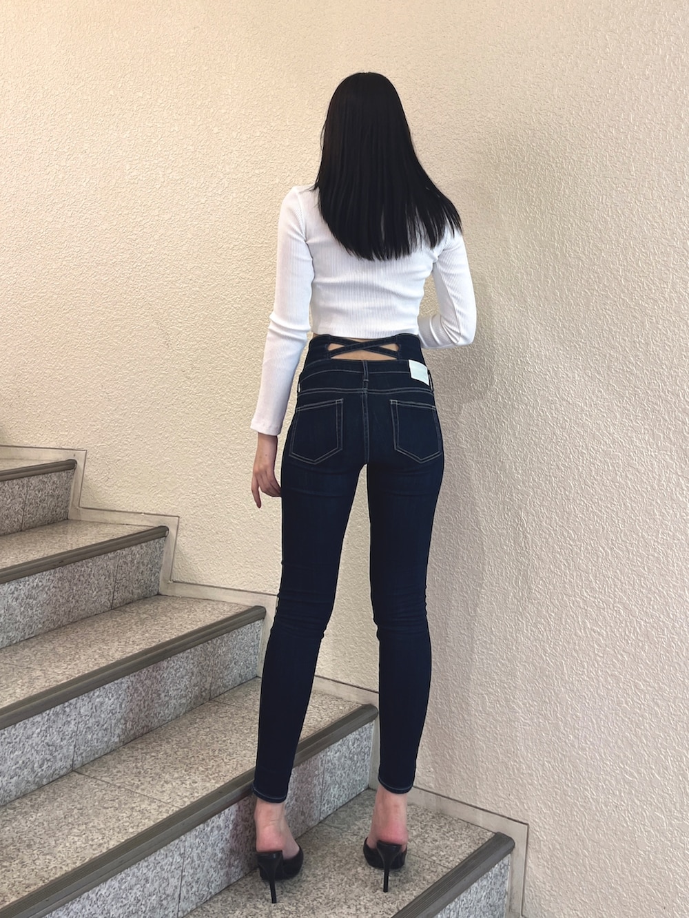 ブルー系のデニムパンツ、ブラック系のパンプス、ホワイト系のTシャツ/カットソーを着用したレディースの春コーディネートの3枚目の写真