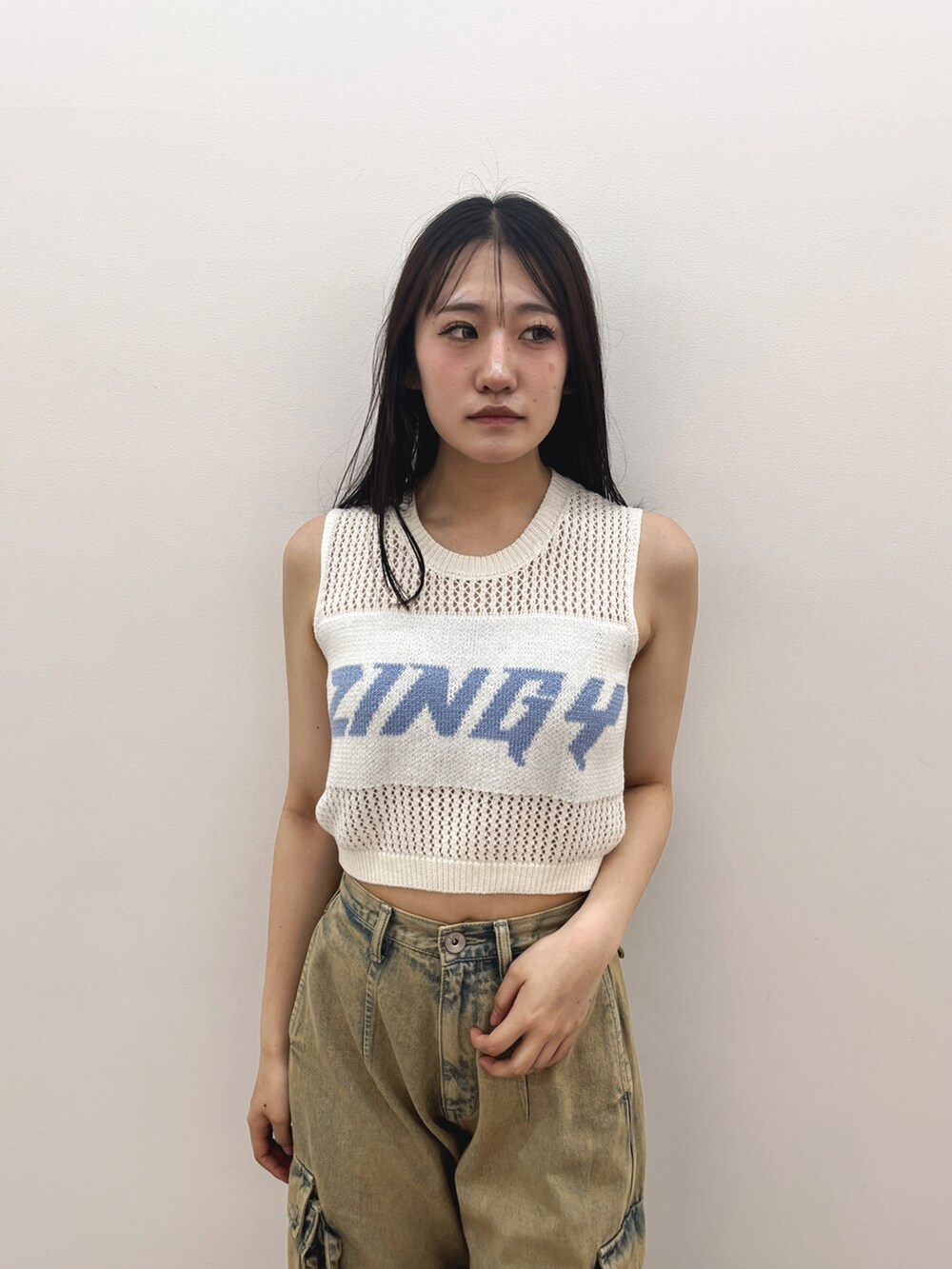 ホワイト系のタンクトップ、ブルー系のデニムパンツ、ホワイト系のパンプスを着用したレディースの夏コーディネートの7枚目の写真