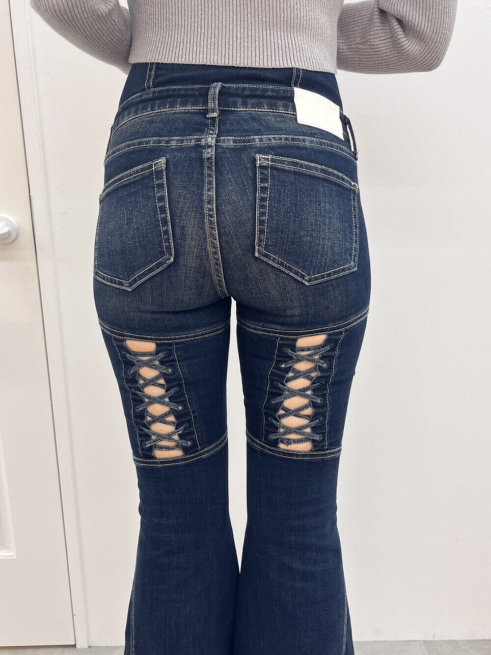 ブラック系のブーツ、シルバー系のニット/セーター、ブルー系のデニムパンツを着用したレディースの秋コーディネートの5枚目の写真