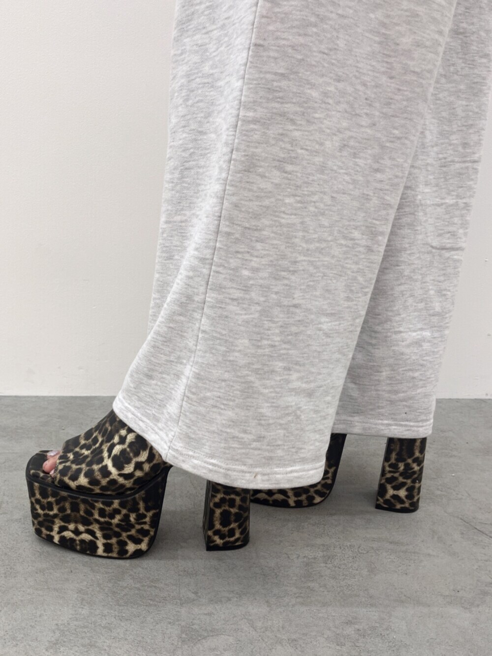 ホワイト系のキャミソール、グレー系のパーカー、グレー系のスウェットパンツを着用したレディースの春コーディネートの6枚目の写真