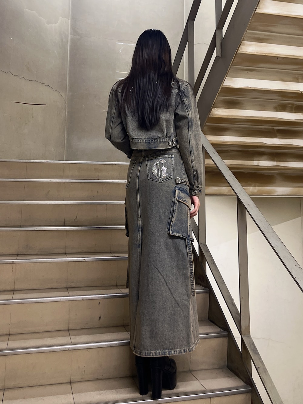 ブルー系のデニムジャケット、ブルー系のデニムスカート、ホワイト系のTシャツ/カットソーを着用したレディースの冬コーディネートの3枚目の写真