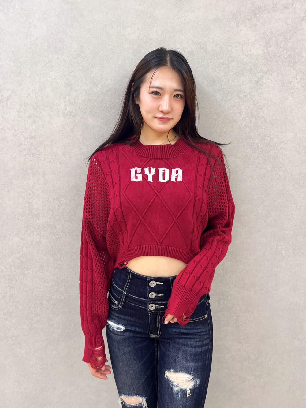 ブルー系のデニムパンツ、ブラック系のサンダル、レッド系のニット/セーターを着用したレディースの夏コーディネートの4枚目の写真