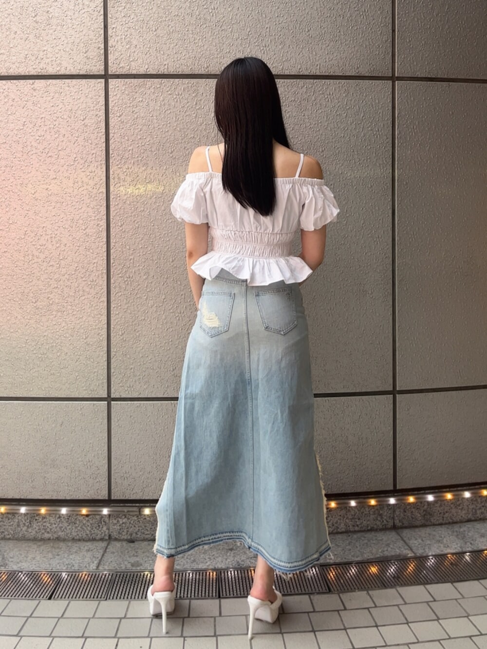 ホワイト系のパンプス、ホワイト系のシャツ/ブラウス、ブルー系のデニムスカートを着用したレディースの春コーディネートの3枚目の写真