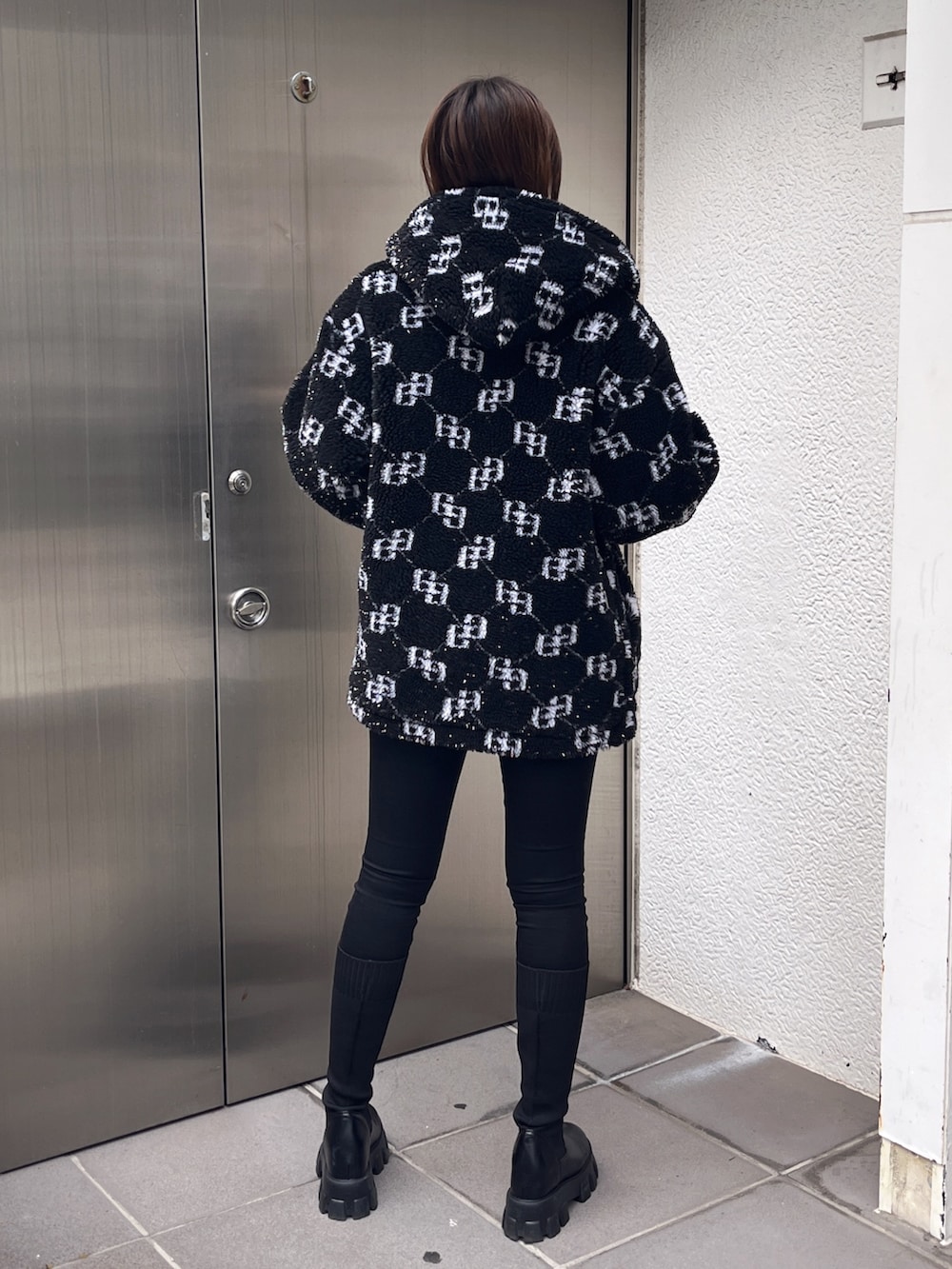 ブラック系のブルゾン、ホワイト系のTシャツ/カットソー、ブラック系のデニムパンツを着用したレディースの冬コーディネートの3枚目の写真