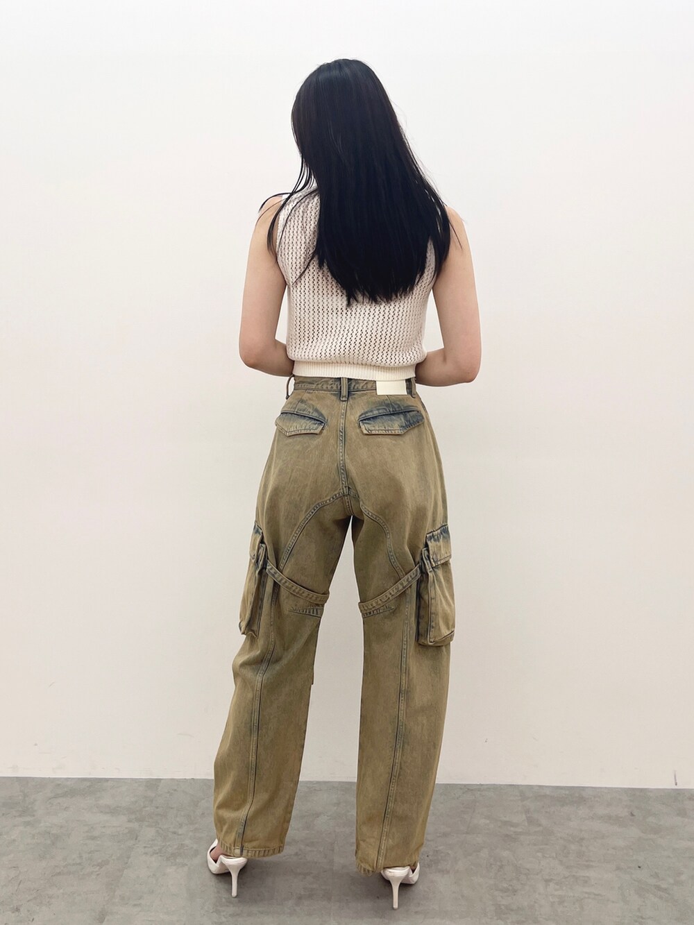 ホワイト系のタンクトップ、ブルー系のデニムパンツ、ホワイト系のパンプスを着用したレディースの夏コーディネートの3枚目の写真