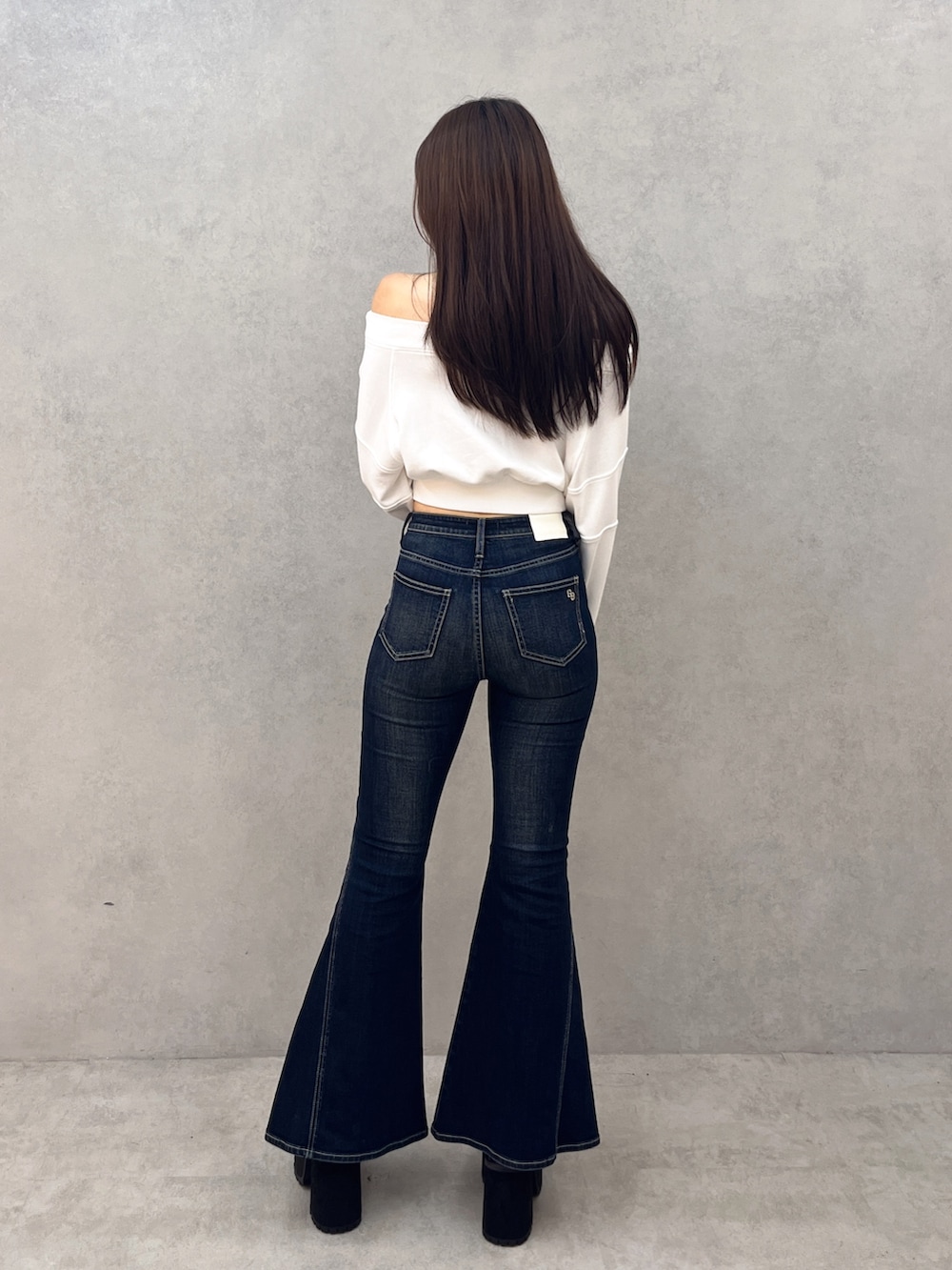 ブルー系のデニムパンツ、ブラック系のブーツ、ホワイト系のTシャツ/カットソーを着用したレディースの秋コーディネートの3枚目の写真