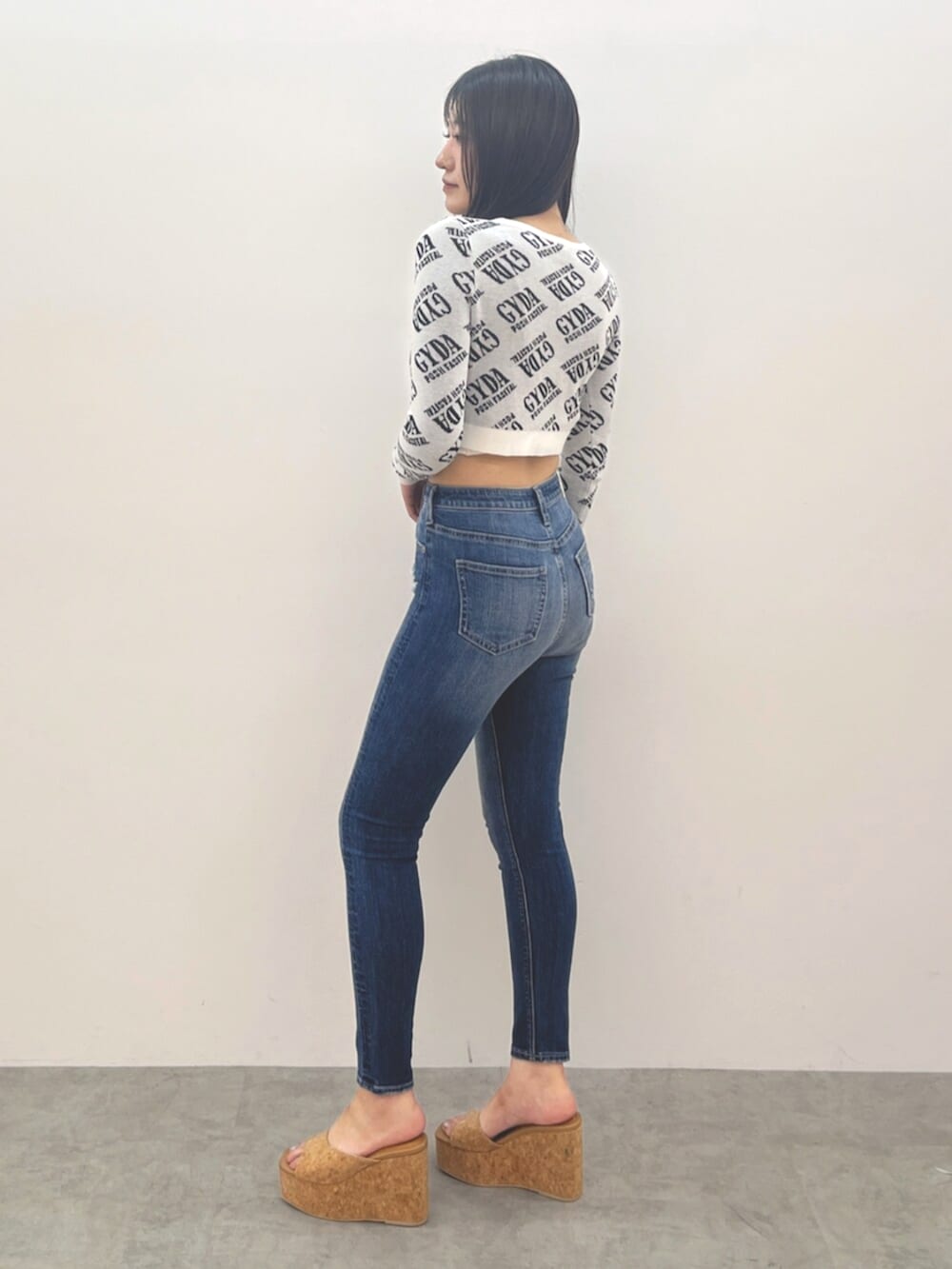 ブルー系のデニムパンツ、ホワイト系のカーディガン/ボレロ、ベージュ系のサンダルを着用したレディースの夏コーディネートの2枚目の写真
